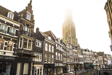 909006 Gezicht op de panden aan de Vismarkt te Utrecht, vanaf de Stadhuisbrug, met op de achtergrond de Domtoren in de mist.